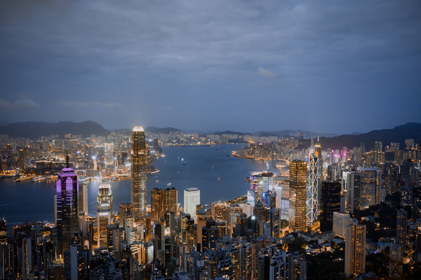 入夜後的香港商業區與維多利亞港,高樓辦公室和中銀大廈亮起燈光。